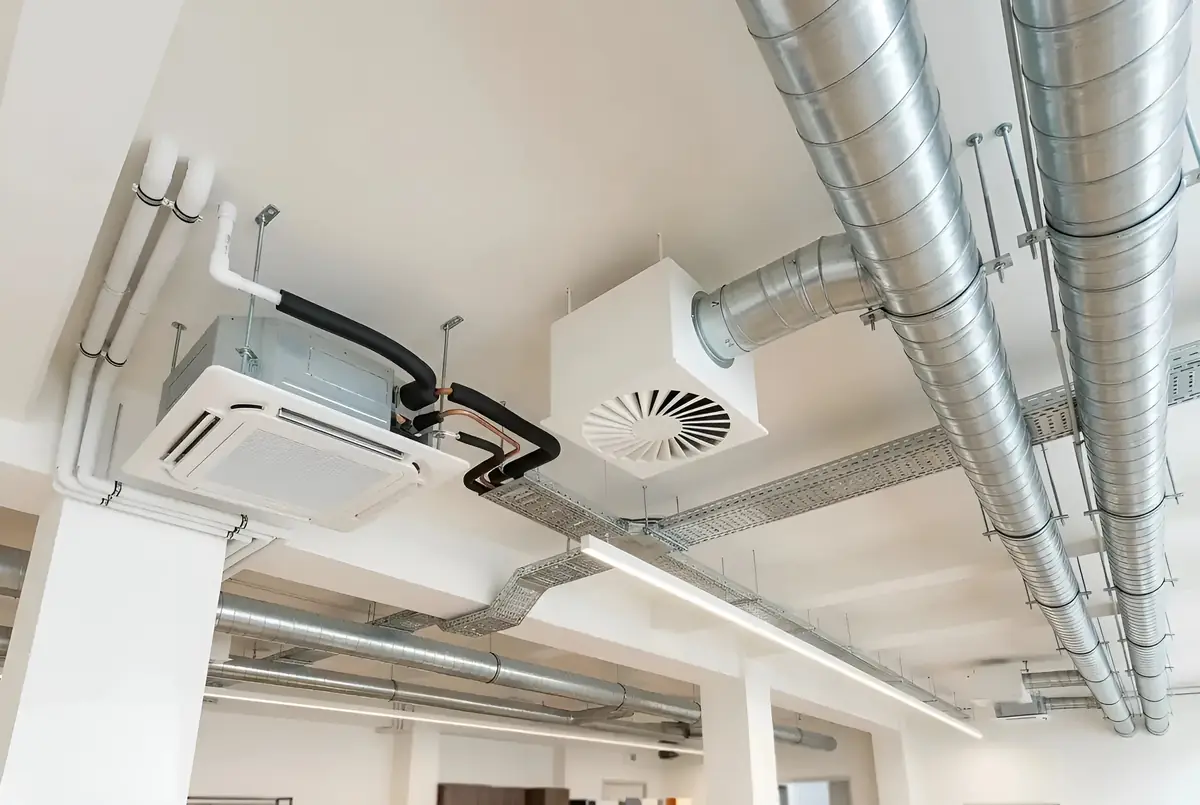 Climatizzatore a cassetta, diffusore elicoidale e condotte spiroidali a vista nel soffitto di un locale commerciale